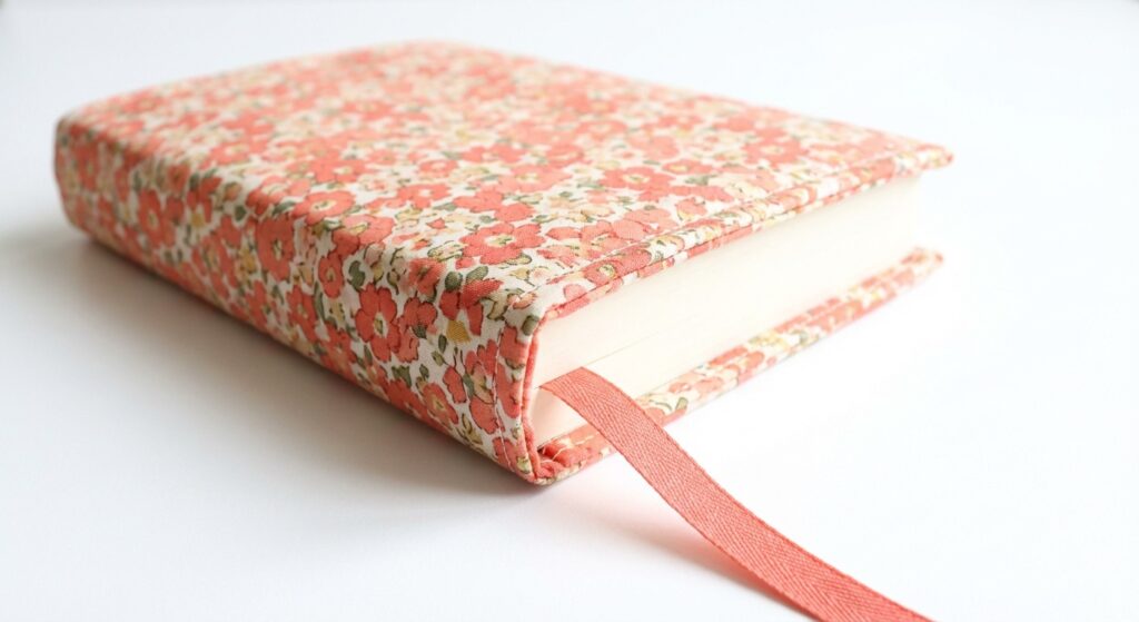Selbstgenähte Buchhülle aus geblümtem Baumwollstoff mit Lesezeichen